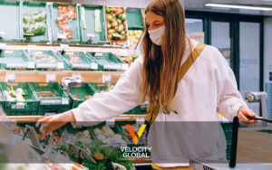 Velocity Global- woman shopping with a mask on