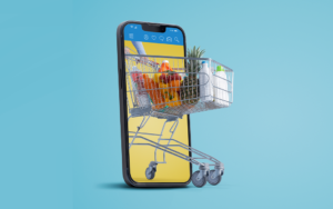 Improving Your Food & Beverage Brand's Amazon and E-Commerce Presence - ChefsBest blog | Graphic of a shopping cart full of groceries coming out of a cell phone on a blue background